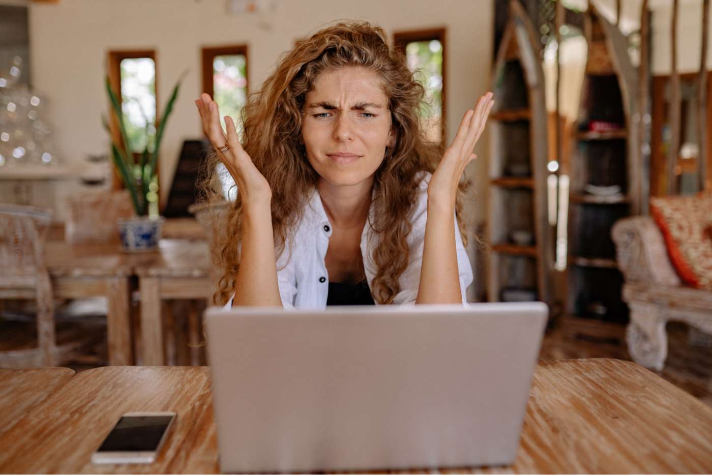 Chica con cara de problemas frente a sus laptop en un restaurante