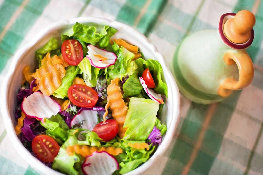 Tazón de ensalada saludable  sobre una mesa con mantel verde