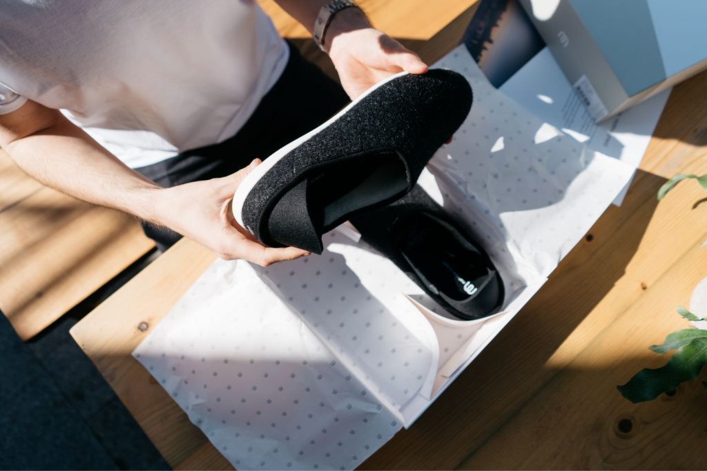 Vender en e-commerce durante temproada alta, chico con caja de zapatos