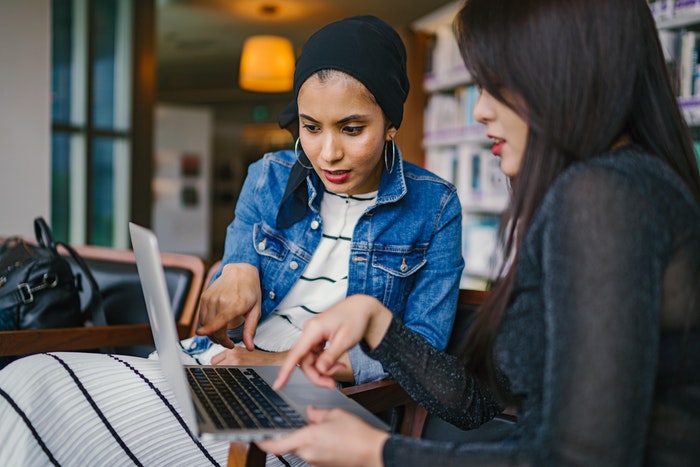 Chicas con laptop observando diseño de página web UX Y UI: Conoce las diferencias, Qué es el diseño UX?