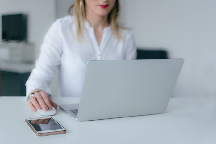 Mujer en oficina con macbook 7 trucos que te ayudarán a aumentar tus conversiones web