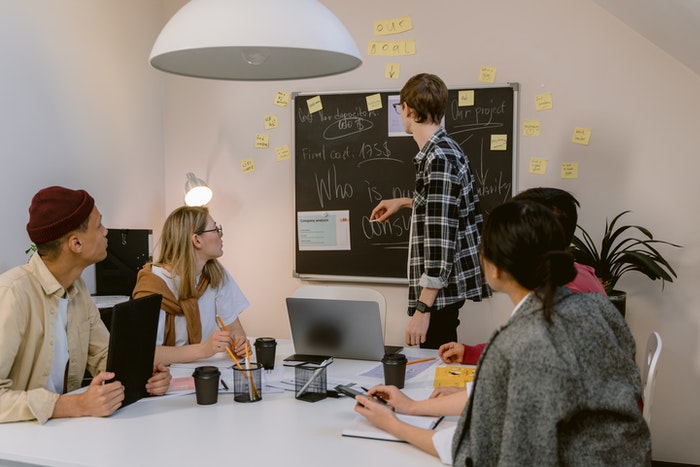 Equipo de trabajo, anotando ideas definitivas en pizarra Los 4 pasos de oro que te ayudarán a elaborar un plan de marketing digital, paso nro 4