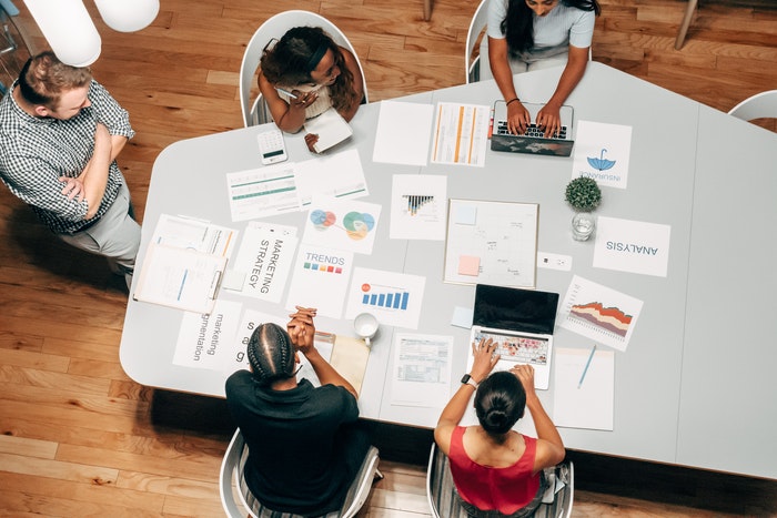 Equipo reunido en oficina Errores más comunes que puedes cometer al segmentar un mercado objetivo, ¿Cuáles son los errores más comunes al momento de segmentar un mercado o público?