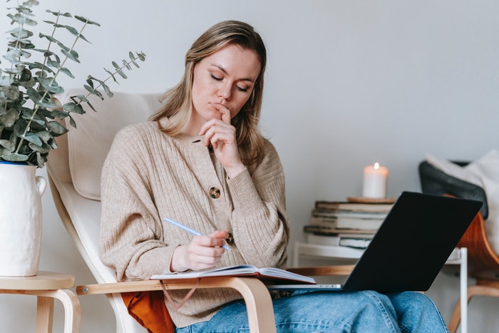Mujer escribiendo en libreta y en macbook 6 Reglas de oro para elaborar un storytelling, Determina cuál es el mensaje principal que vas a transmitir