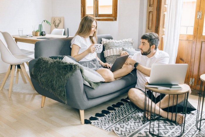 Chico y chica sentados con macbook 5 Tips para aumentar tus ventas en temporada baja, Tip 1: Crea un concurso especial
